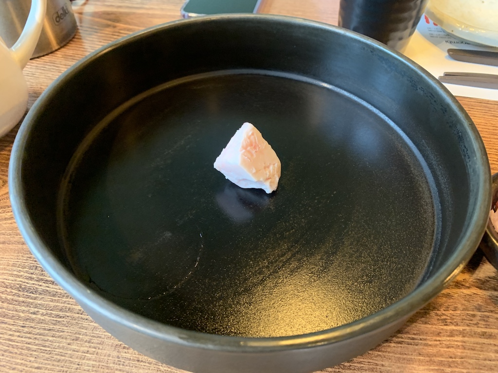 a black bowl with a piece of food in it