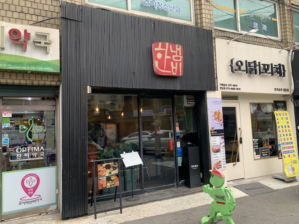 a store front with a green toy in front of it