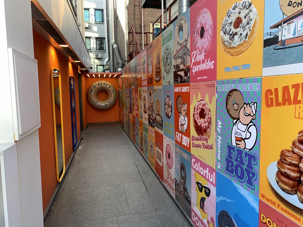 a sidewalk with a wall of posters