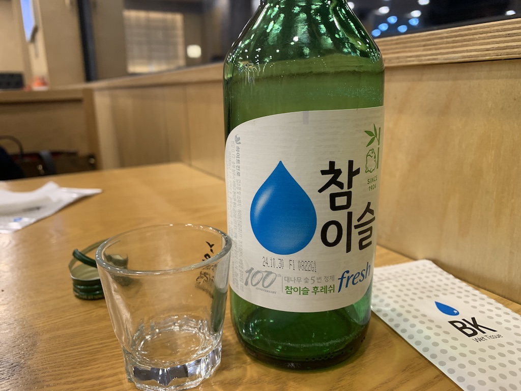 a bottle of liquid and a glass on a table