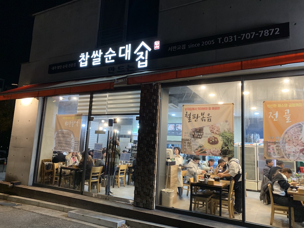 a restaurant with a sign above the door