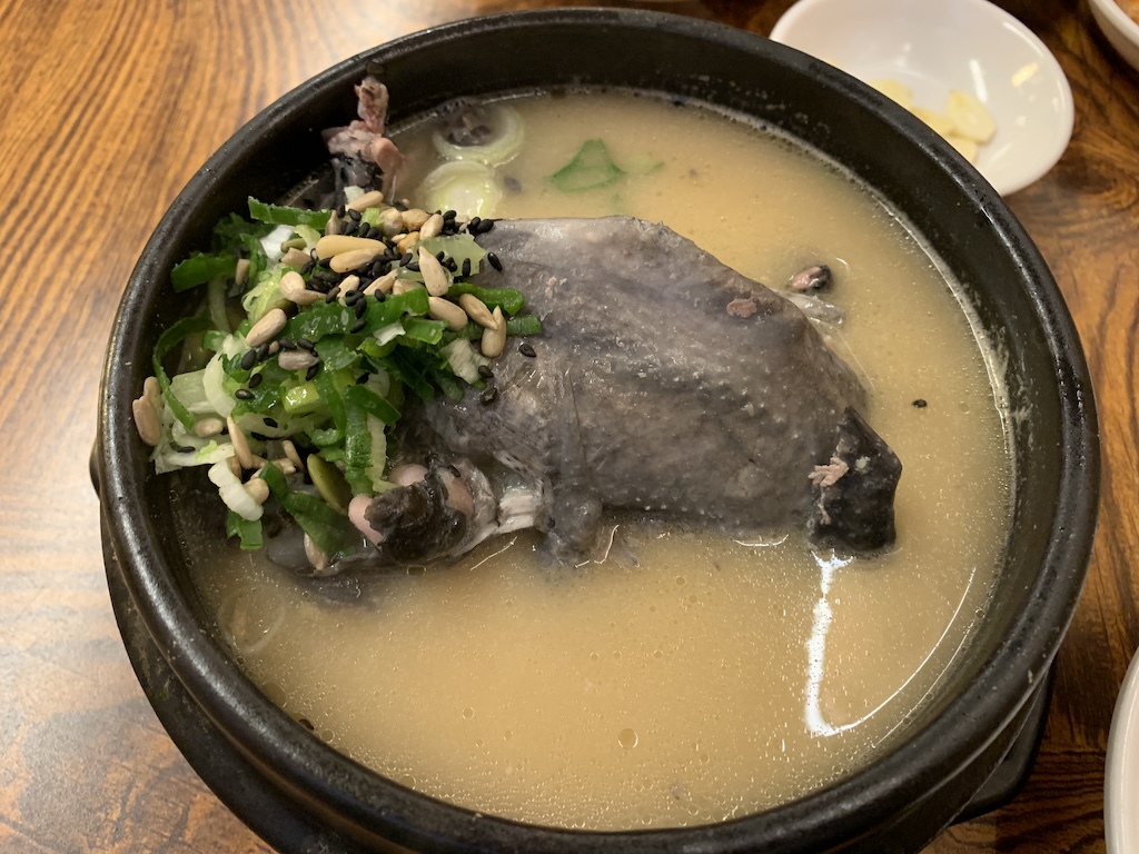 a bowl of soup with a fish in it