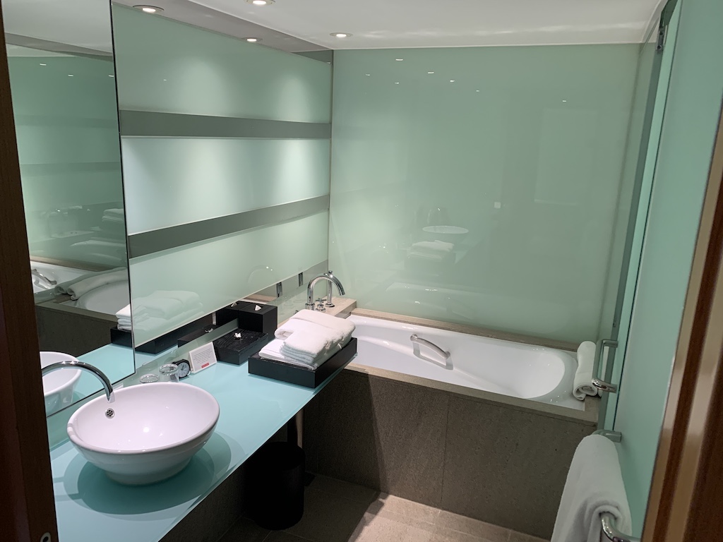 a bathroom with a tub sink and a mirror