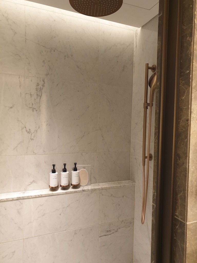 a shower with bottles on the shelf