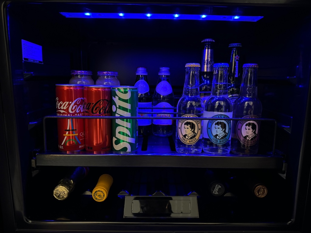 a shelf with soda cans and bottles on it