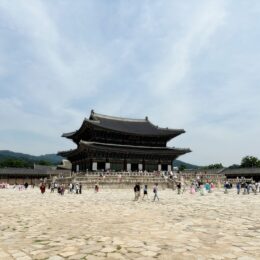 a large group of people at a large building with Gyeongbokgung in the background