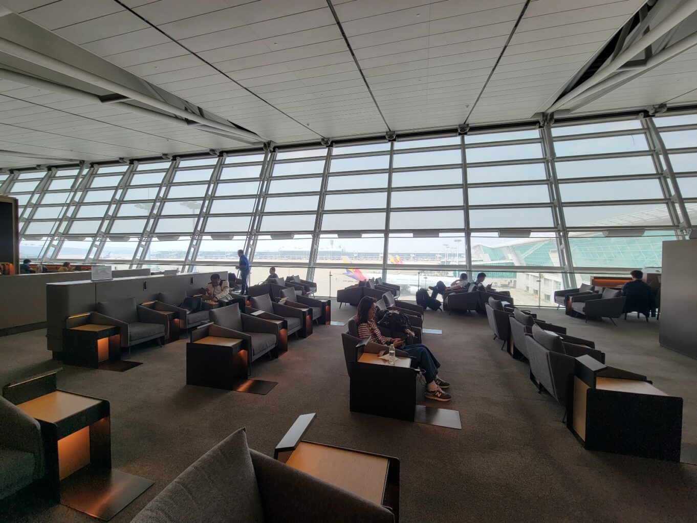 a group of people sitting in a room with large windows