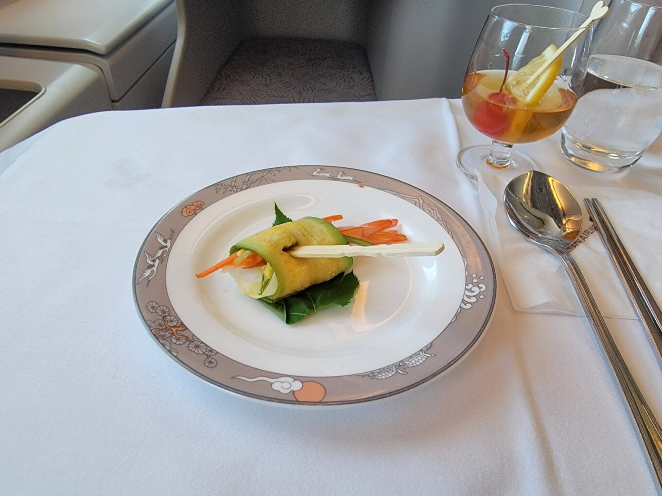 a plate of food and glasses of wine on a table