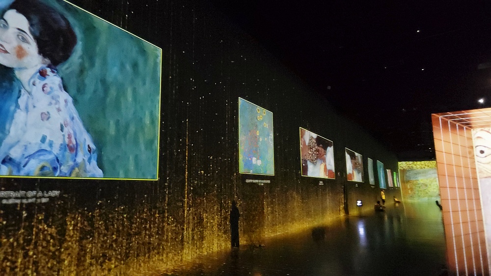 a person standing next to a wall of pictures