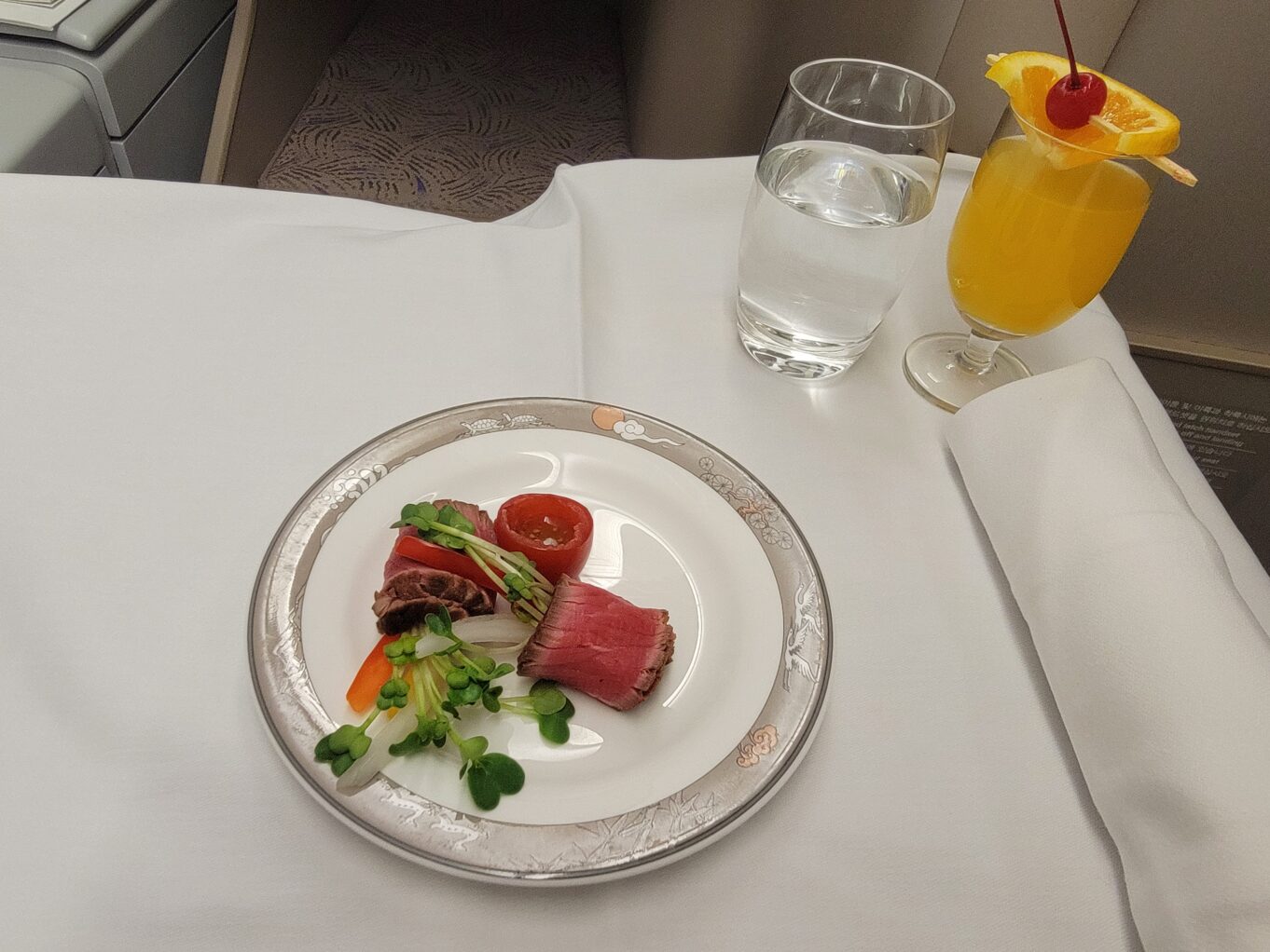 a plate of food and glasses of juice on a table