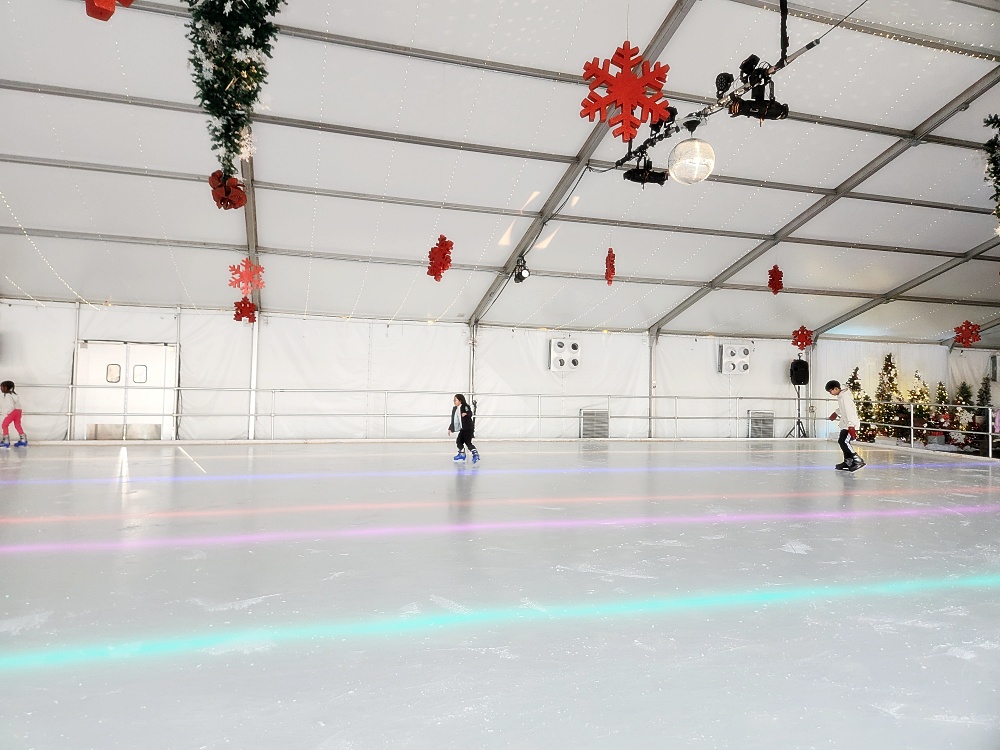 a group of people on an ice rink with lights