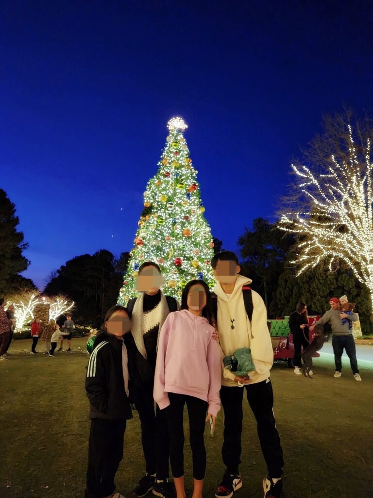 a group of people standing in front of a christmas tree