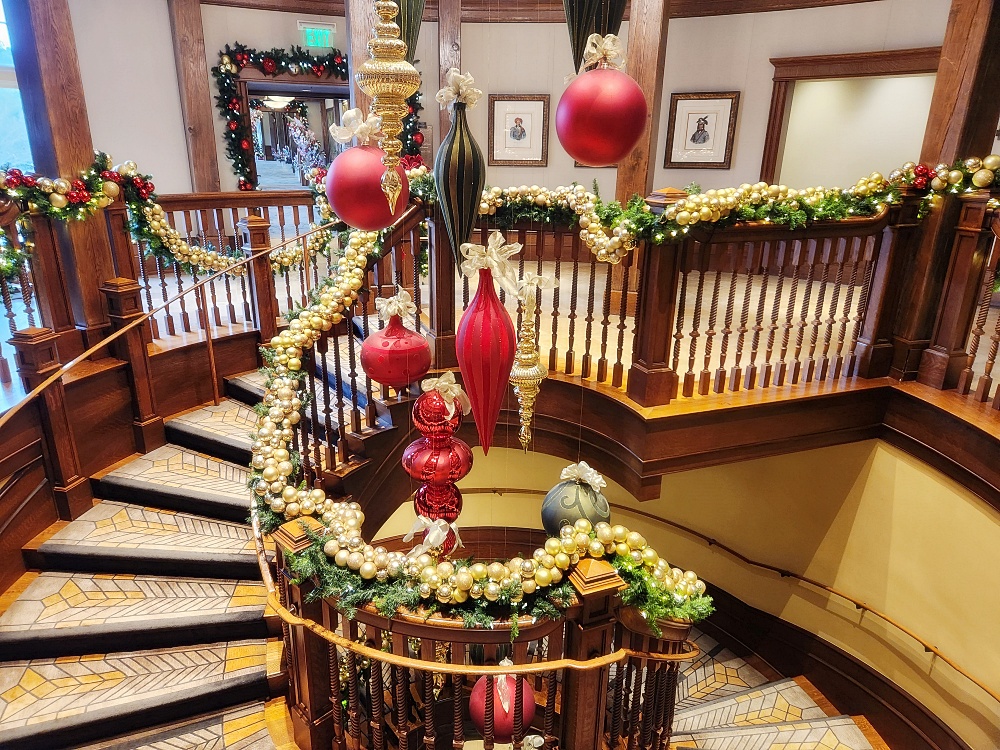 a room with a table and chairs with flowers and a staircase