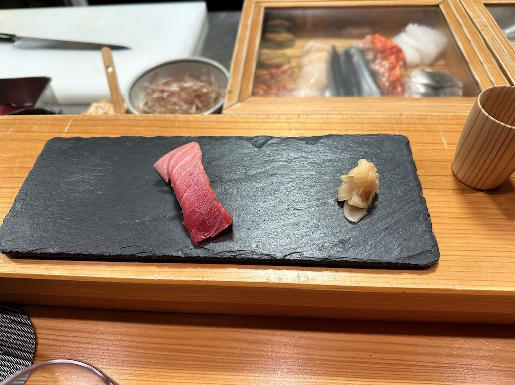 a black rectangular object with a pink ribbon on a wooden surface