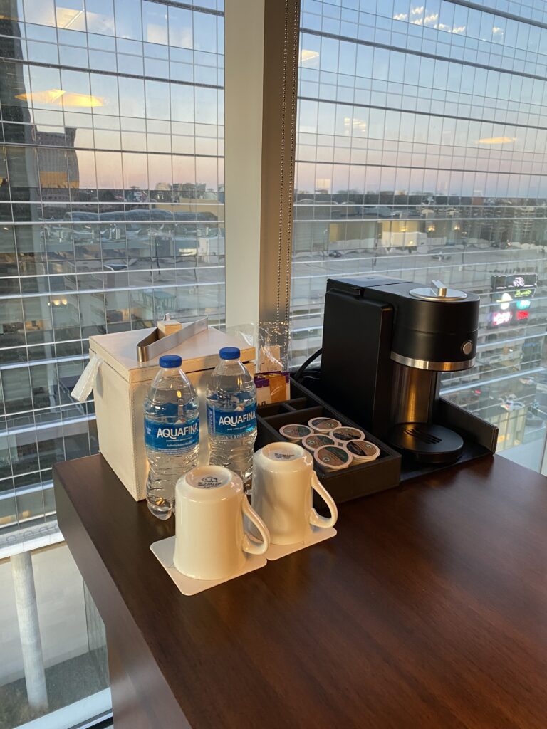 a table with a coffee maker and a couple of bottles of water