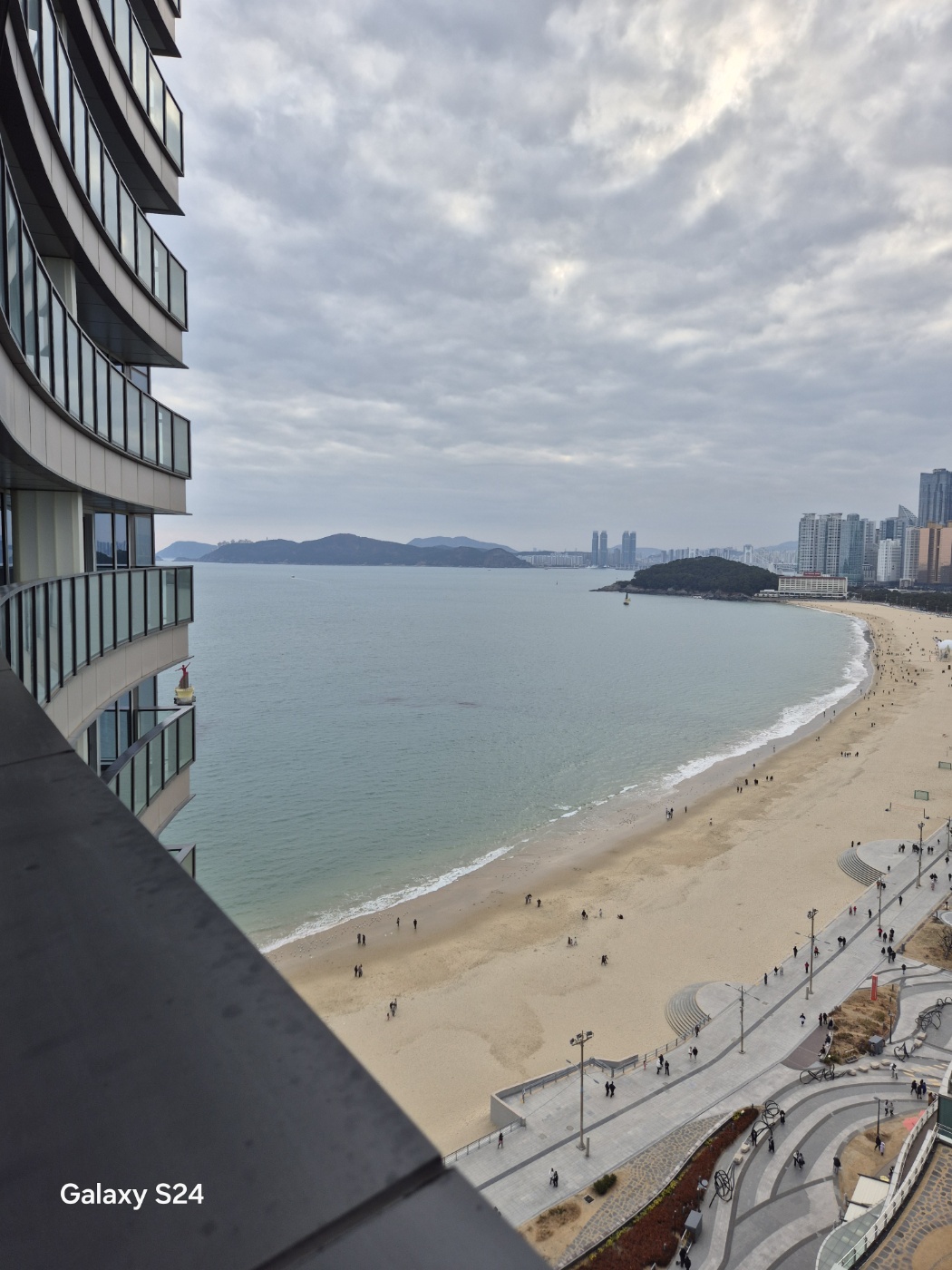 a beach with a body of water and buildings in the background