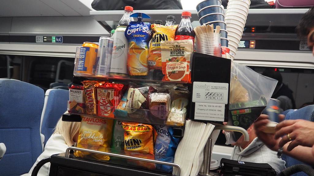 a person holding a cup and a bag of chips