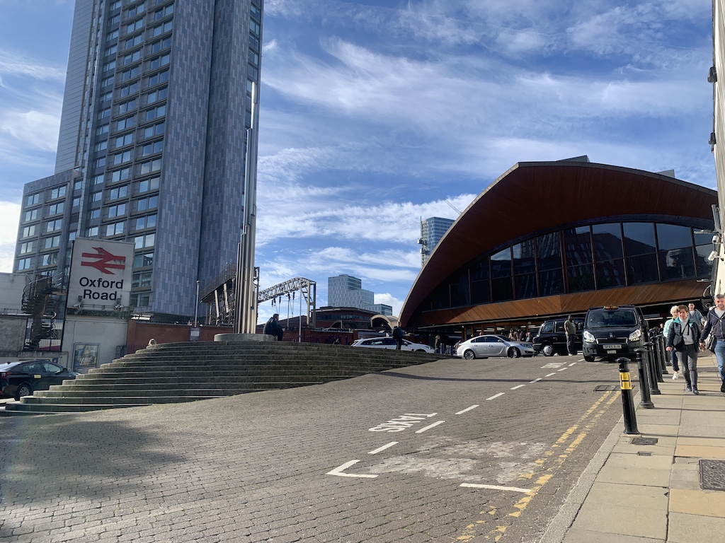 a street with cars and people on it next to a building