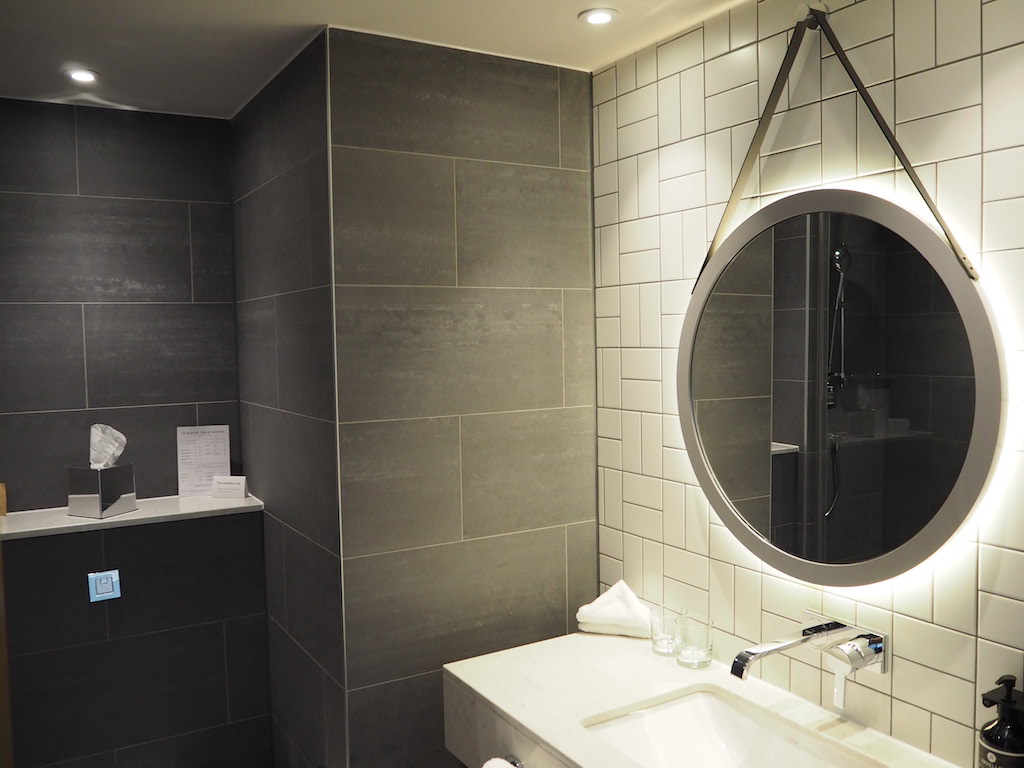 a bathroom with a round mirror