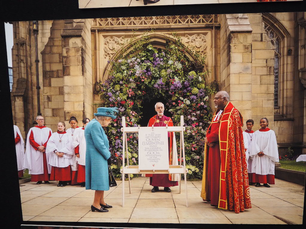 a group of people in robes and hats standing in front of a casket