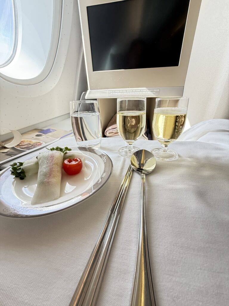 a plate of food and glasses of wine on a table