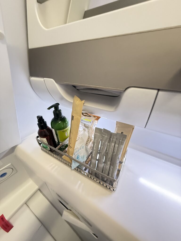 a white refrigerator with a couple of bottles and a couple of bags of chips in it