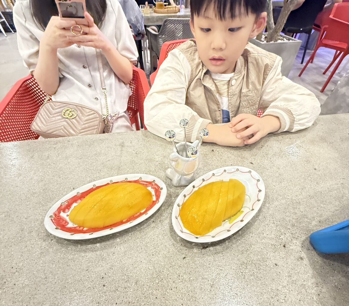 a child sitting at a table with food on it