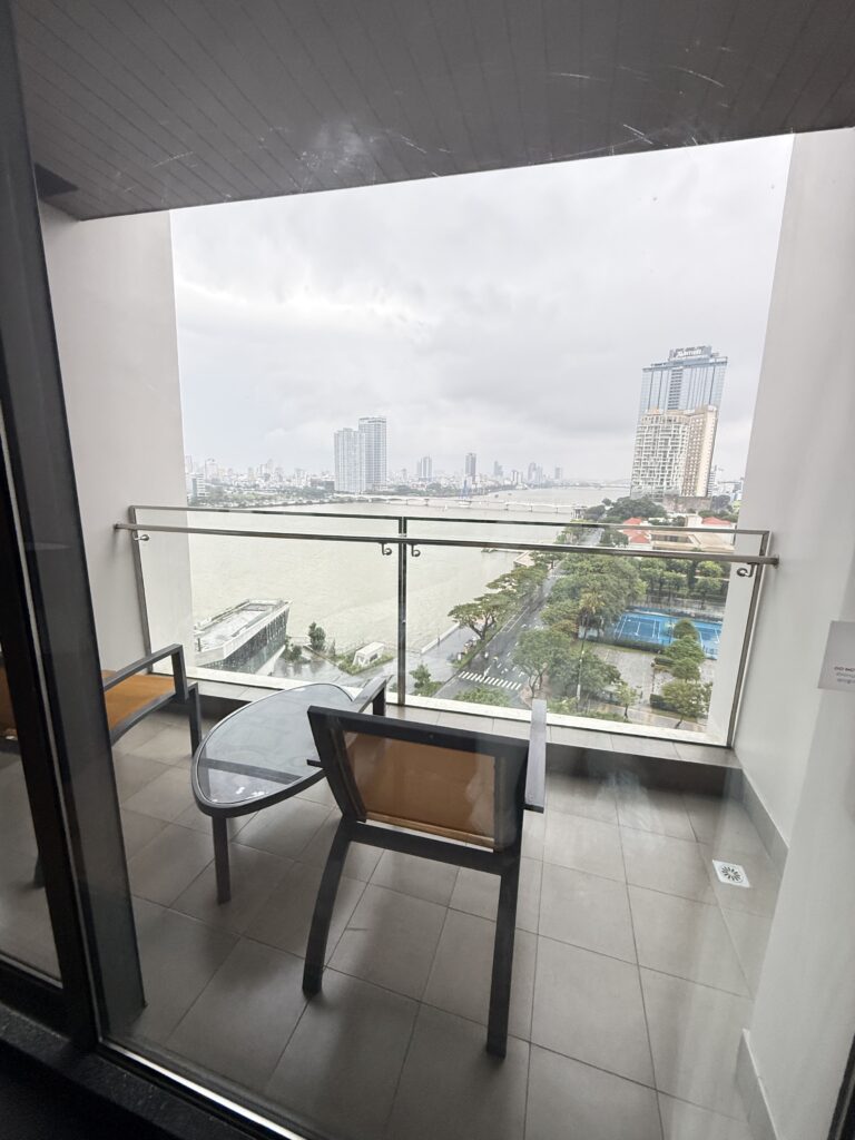 a chair and a table on a balcony overlooking a city