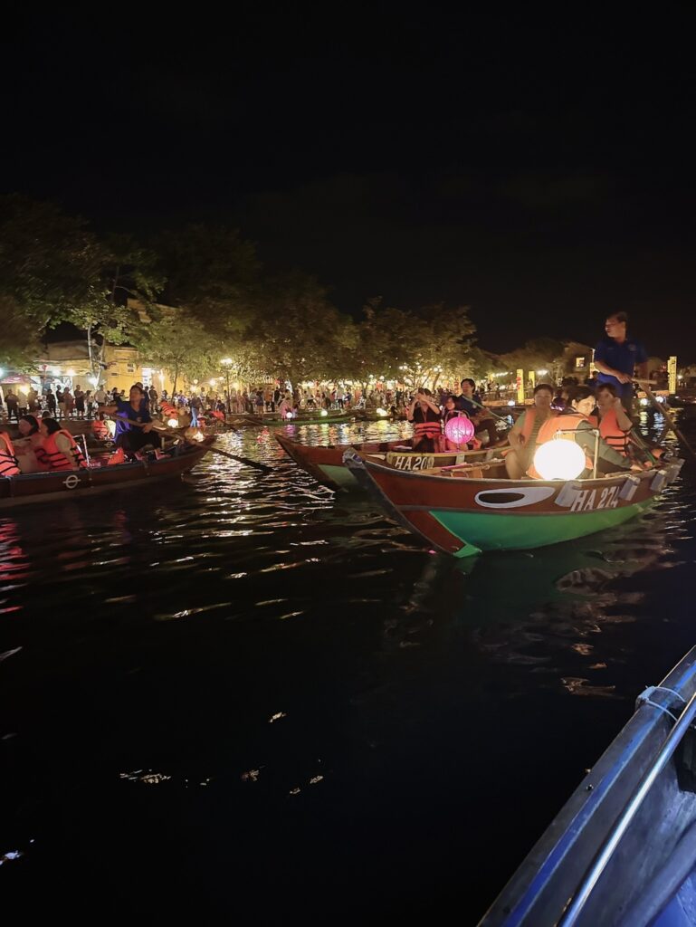 a group of people on boats in a river at night