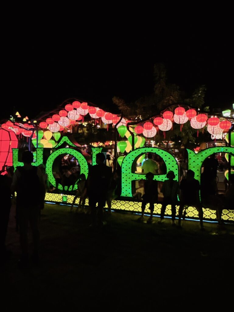 a group of people standing next to a carousel