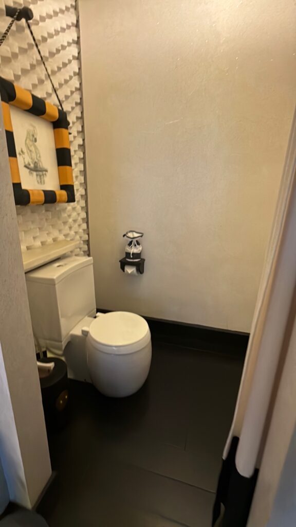 a bathroom with a toilet and a painting on the wall