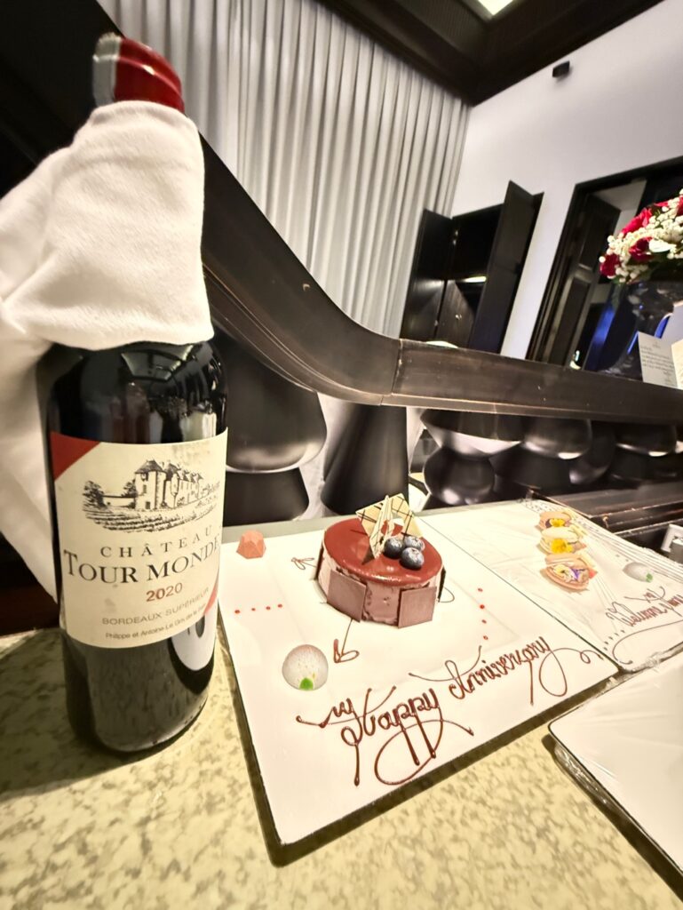 a bottle of wine next to a cake