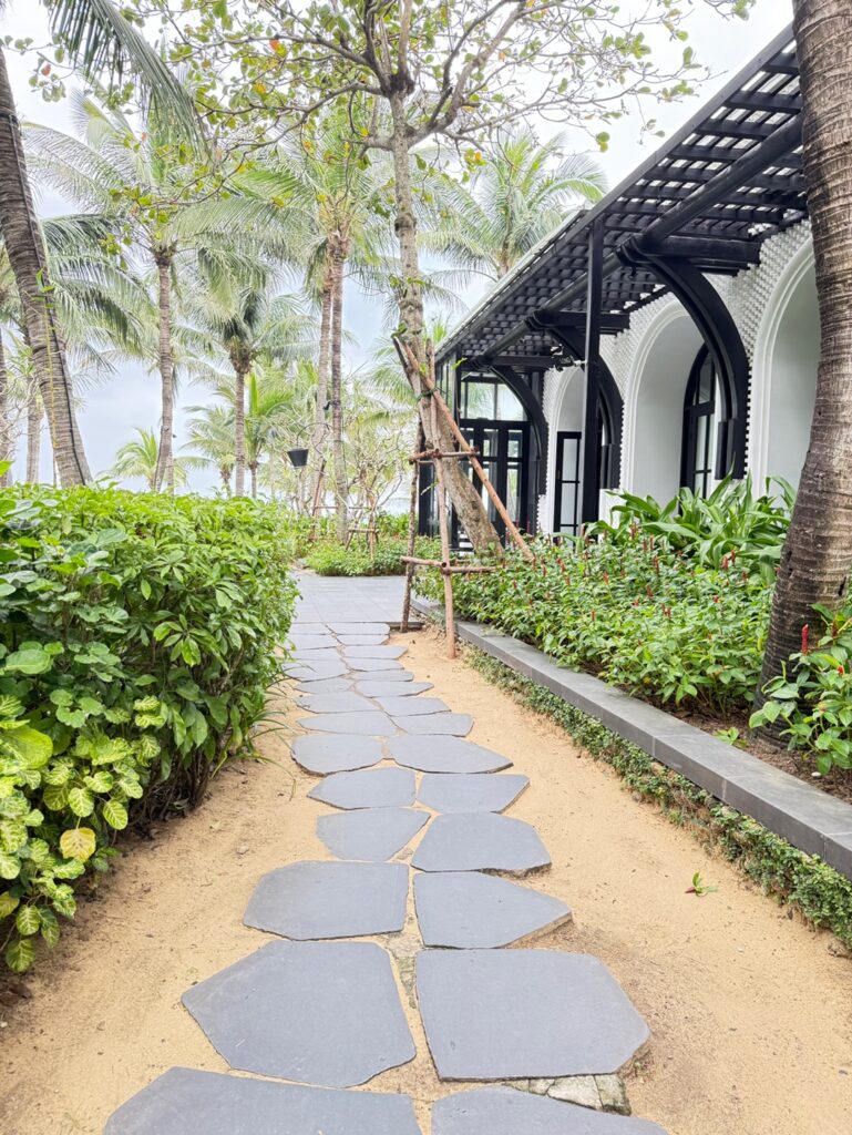 a stone path with plants and trees