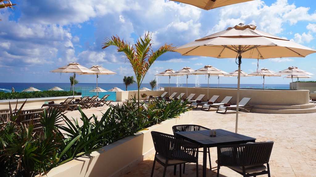 야외, 하늘, 가구, 테이블, 우산, 구름, 해변, 그늘, 일광욕 의자, 물, 야외 테이블, 리조트, 야외 가구, 해변 리조트, 커피 테이블, 파티오, 카리브해, 열대, 식물, 리조트 타운, 의자, 지상, 휴가, 호텔, 대양