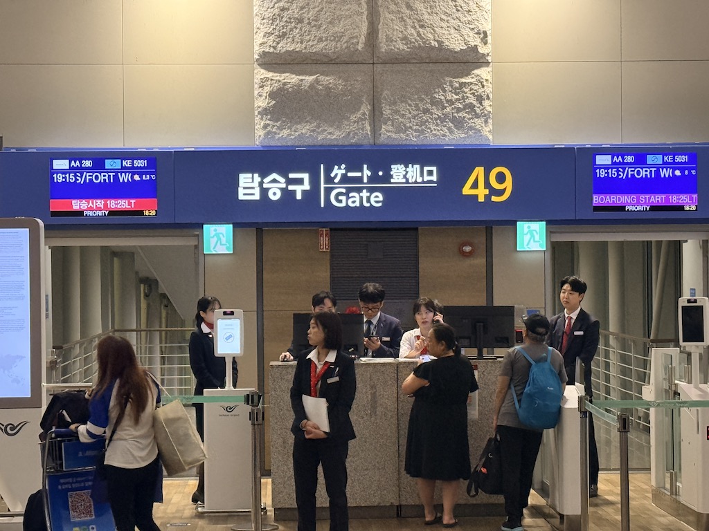 의류, 텍스트, 신발류, 여성, 사람, 사람들, 수하물 및 가방, 실내, 스탠딩, 현금 인출기, 그룹, 문, 공항